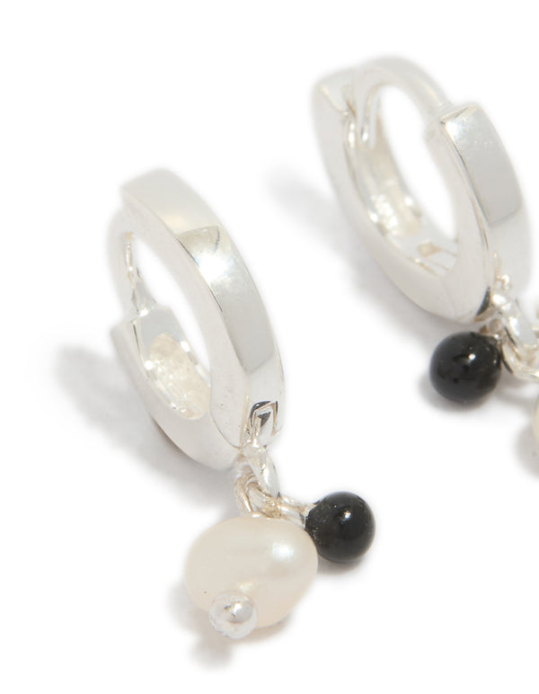 Elegant sterling silver drop huggie earrings with beaded charm featuring pearl and black stone accents close up view