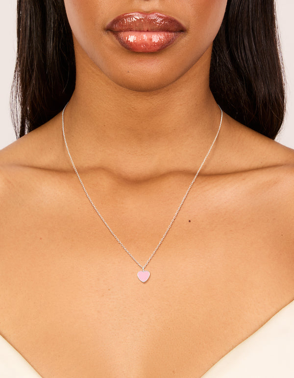 Showcasing a sterling silver pink enamel heart pendant necklace on neck view