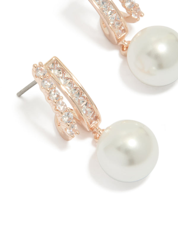 Elegant rose gold plated cubic zirconia illusion pearl drop earrings with hoop closure in ivory close up view
