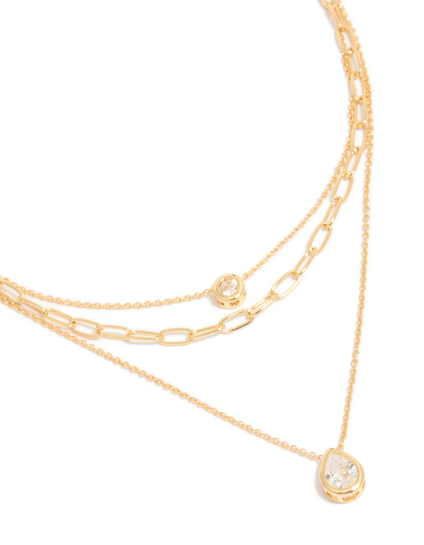 Showcasing a gold plated cubic zirconia bezel triple layered chain necklace dainty styling in close up view