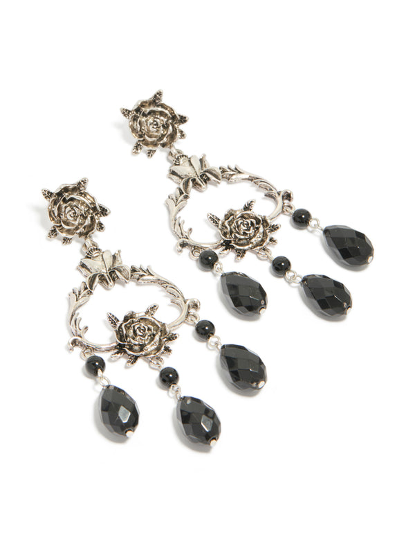 Showcasing drop earrings featuring floral design with beaded accents, charm elements in silver and black statement style front view