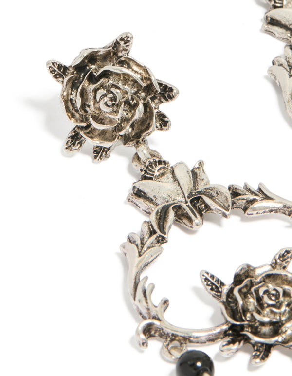 Elegant rose drop earrings with floral, beaded and charm details in silver and black statement style close up view