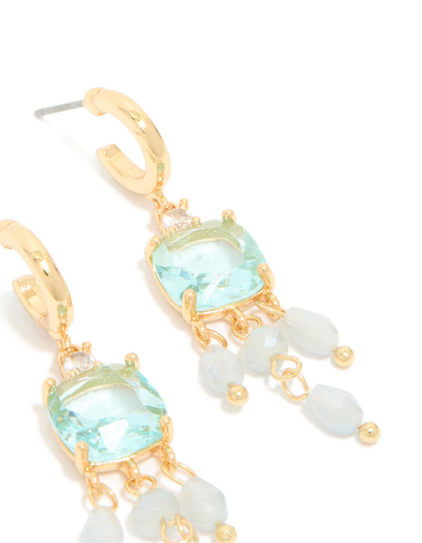 Presenting gold plated blue cubic zirconia square drop earrings with stone and bead details, accented with charms in a statement style, post detail view