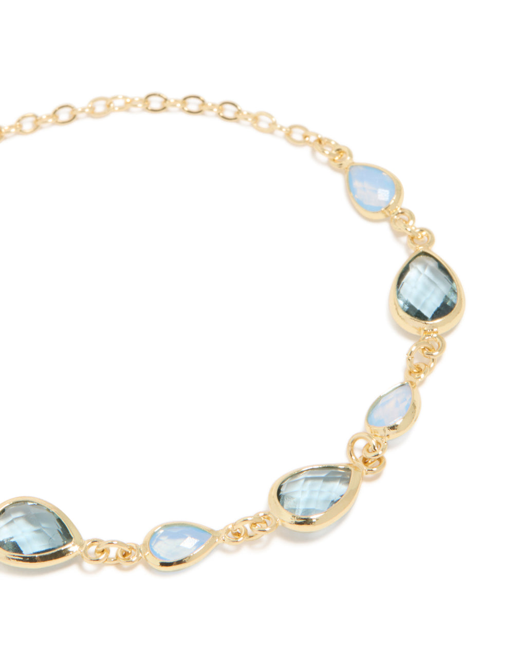 Showcasing bracelet crafted from gold plated metal with deep blue cubic zirconia stones in a statement design close up view