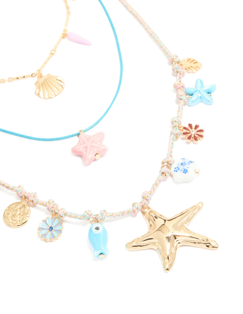 Showcasing gold blue cord sea charm layered necklace featuring floral, leaf, ocean and coin close up view