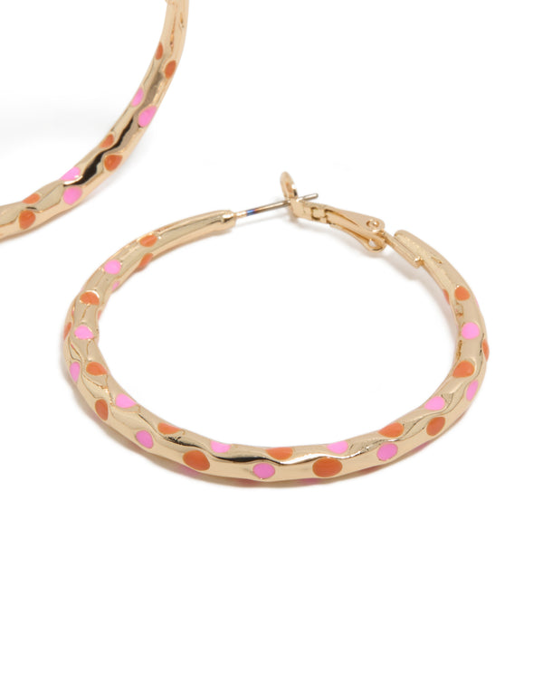 Presenting large statement hoop earrings with enamel dotted pattern in pink and orange on thin closure post detail view
