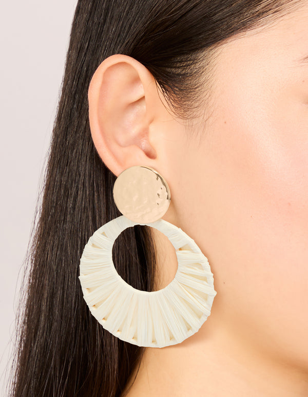 Crafted from ivory and gold materials, these raffia paper circle drop earrings feature statement styling on ear view