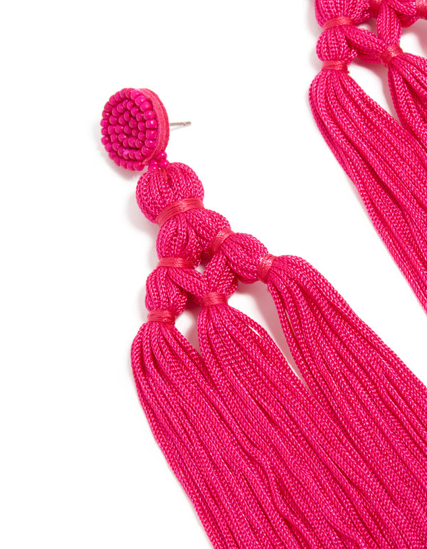 Highlighting statement hot pink fabric tassel drop earrings with beads and post detail view