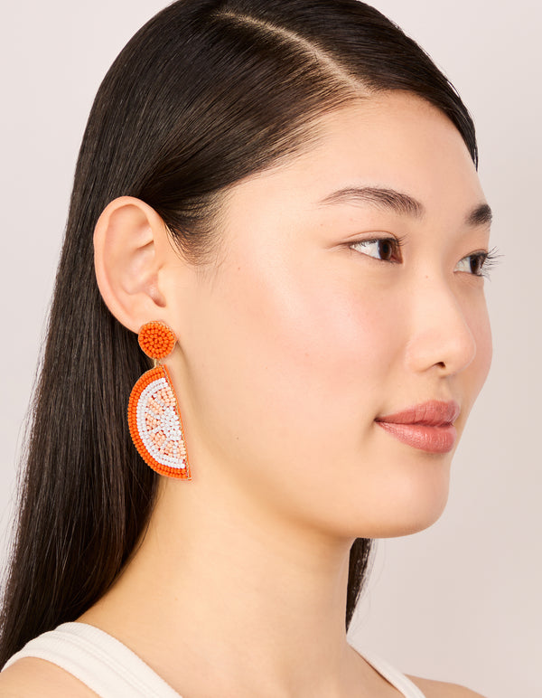 Designed with beaded fruit elements in orange white and peachpuff statement drop earrings on model view