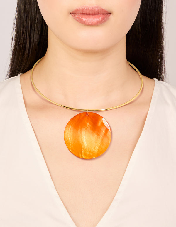Showcasing a gold orange genuine shell disc torque necklace in a chunky style on neck view