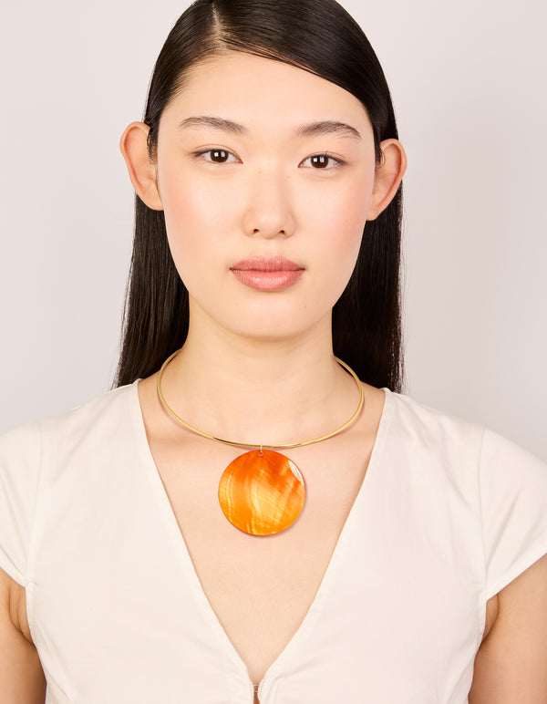 Presenting a gold orange genuine shell disc torque necklace in a chunky style on model view