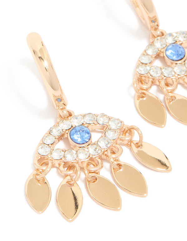 Crafted with statement evil eye charm accents, these gold huggie earrings are shown in close up view