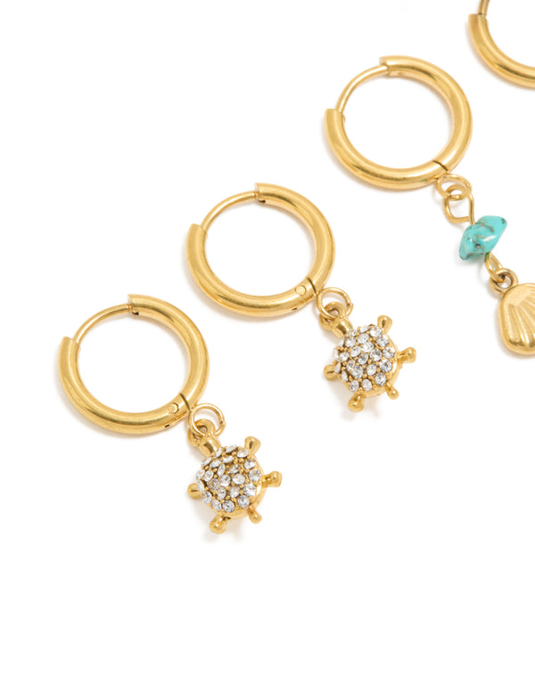 Designed with waterproof gold plated stainless steel huggie earrings featuring shell turquoise ocean accents in a 2-pack close up view