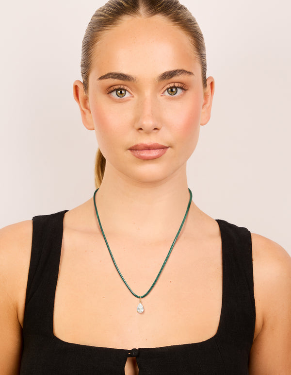 Elegant waterproof necklace with pear cut cubic zirconia pendant on dark green cord, designed in gold plated stainless steel and crystal on model view