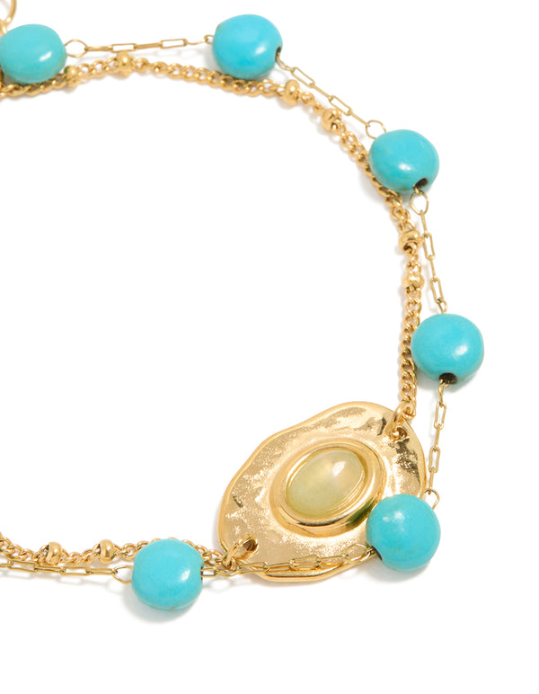 Designed with waterproof beaded stainless steel disc turquoise semi precious stone and green accents bracelet in gold plated finish close up view