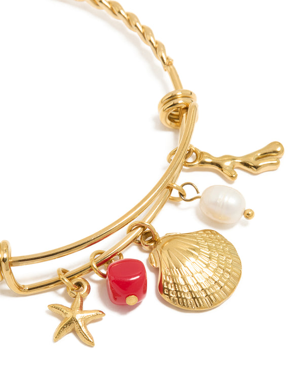 Showcasing waterproof gold plated stainless steel shell and freshwater pearl charm bangle with ocean-inspired motifs close up view