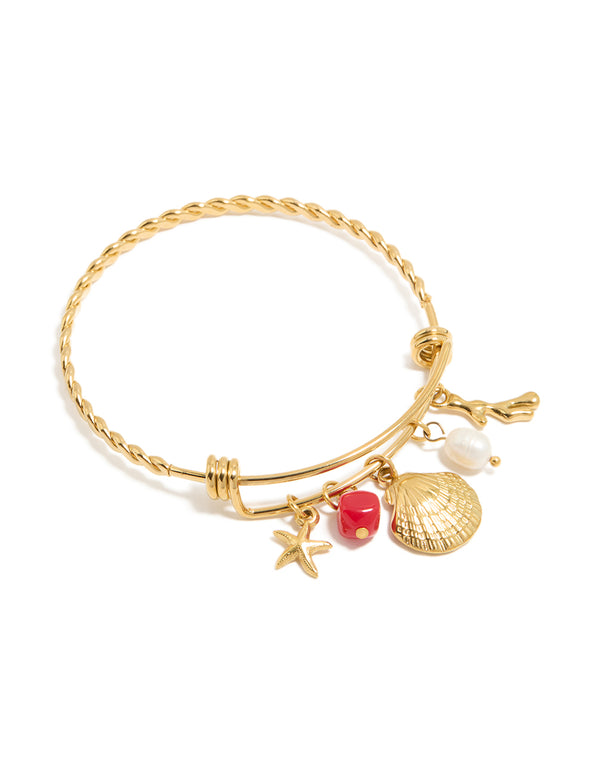 Discover this waterproof gold plated stainless steel shell and freshwater pearl charm bangle featuring ocean-inspired motifs in a beautiful twisted design front view