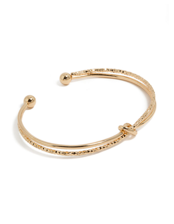 Showcasing a gold textured and smooth knotted wrist cuff bangle front view