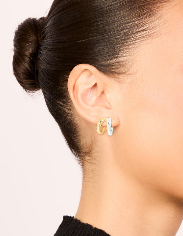 Showcasing mixed metal plated double hoop earrings in gold and silver with hoop closure on ear view
