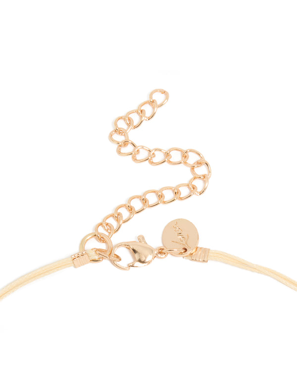Featuring a beaded acrylic yarn necklace in cream and gold tones clasp detail view