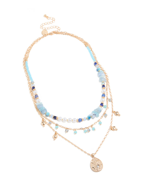 This statement necklace showcases balls, beads, charm, pendant, and pearls in gold with blue stones front view