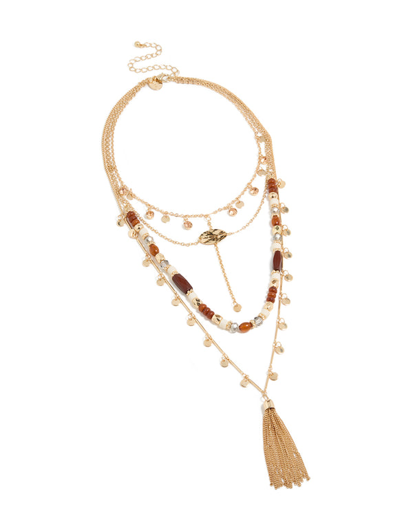 Elegant layered statement necklace featuring beads, tassel, charm and disc in gold front view