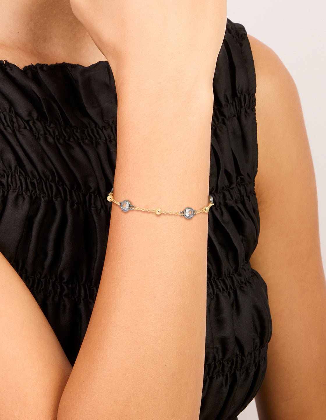 Crafted from mixed metal gold plated finish with cubic zirconia stones and ball chain design bracelet on wrist view