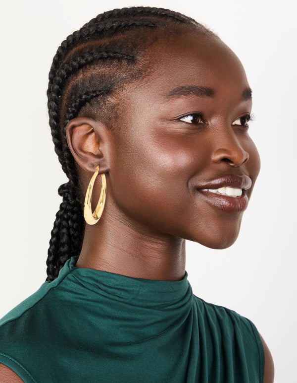 Featuring gold plated thick thin hoop earrings with closure on model view