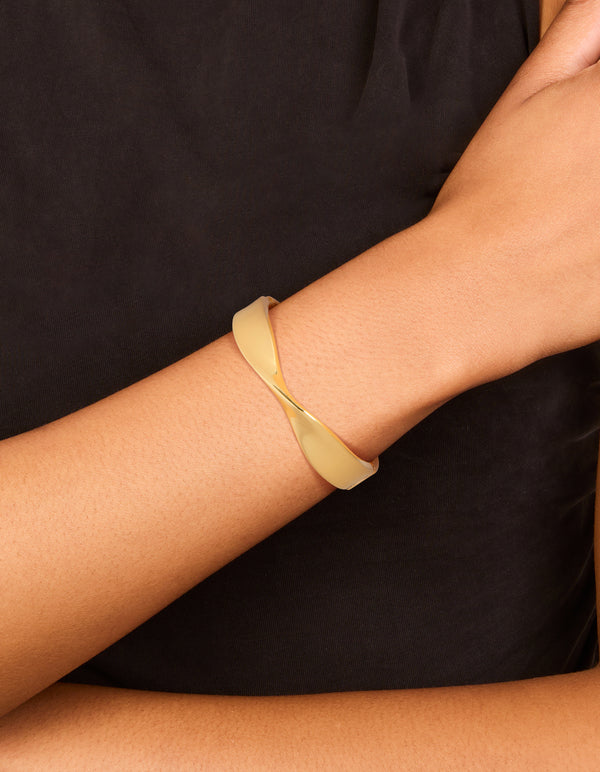 Crafted from gold plated material, this twisted thick bangle in gold with chunky style on wrist view