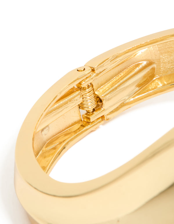 Highlighting gold plated thick curved statement bangle closure detail view