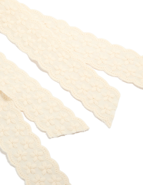 Featuring delicate floral lace fabric, this ivory bow clip showcases intricate detailing in detail view