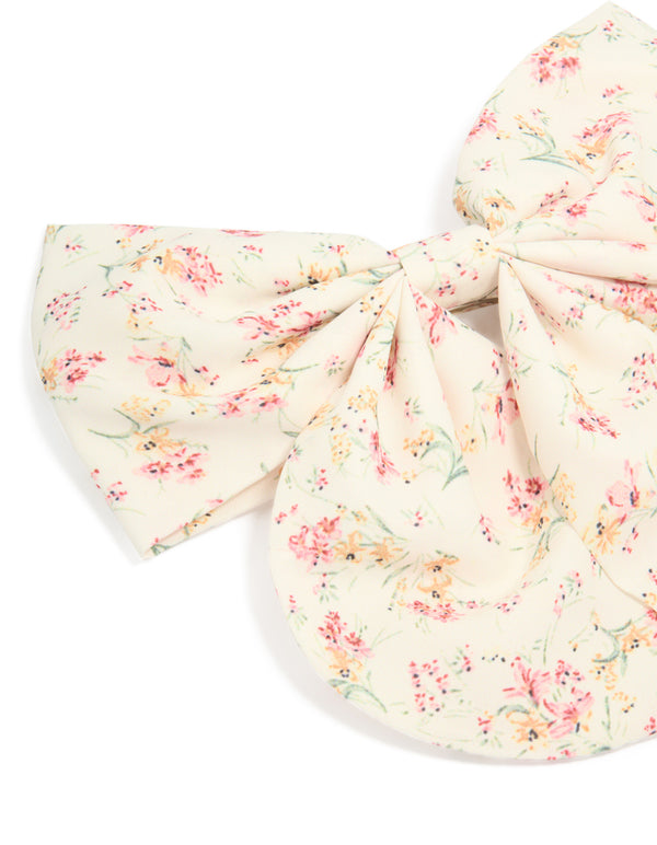 Printed fabric bow clip with floral pattern featuring leaf details in ivory, light pink, peachpuff, and pale green side view