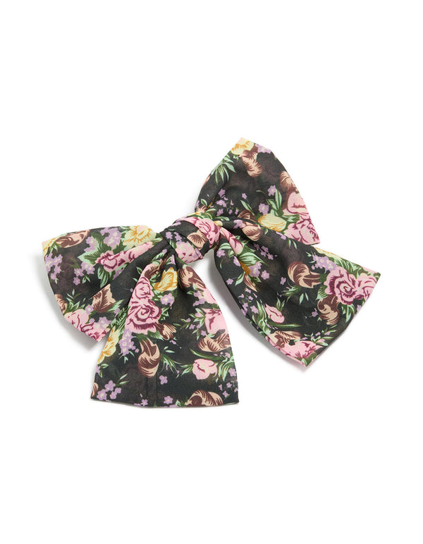 Showcasing a large bow clip with printed flowers in black, pink, green, statement style front view