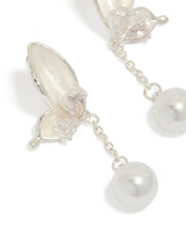 Capturing silver plated enamel butterfly pearl drop earrings featuring charm in ivory and light pink close up view