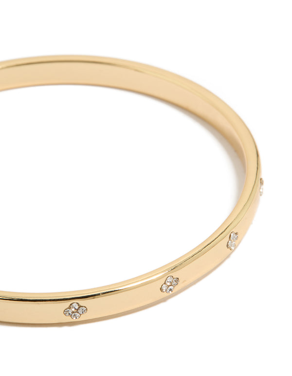 Showcasing gold plated cubic zirconia flowers bezel set bangle with floral pattern in clear and gold tones close up view