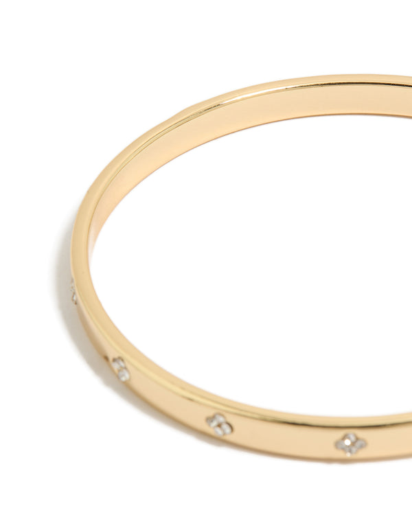 Showcasing gold plated cubic zirconia flowers bezel set bangle with floral pattern in clear and gold tones close up view