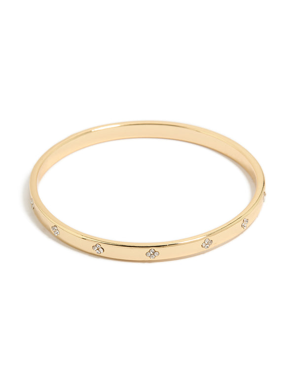 Crafted from gold plated metal, this cubic zirconia flowers bezel set bangle features a floral pattern in clear and gold tones front view