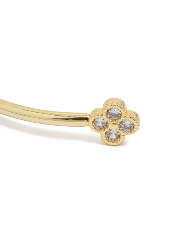 Highlighting a floral statement wrist cuff in gold plated metal with cubic zirconia close up view