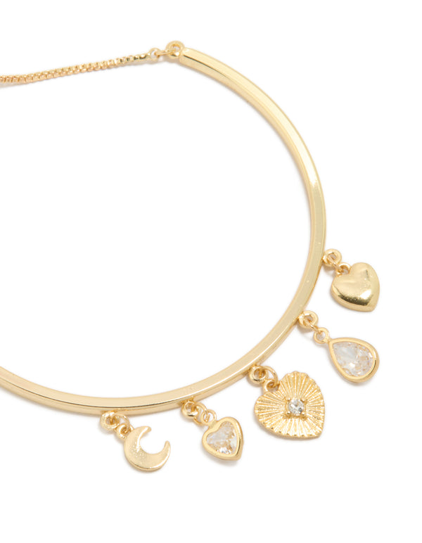 Crafted from gold plated metal, this bangle features celestial moon and heart charm details close up view