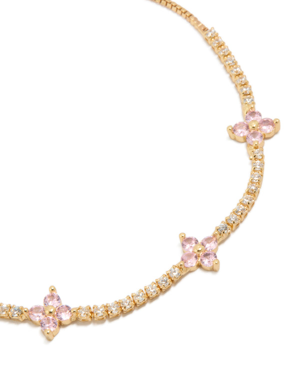 Showcasing a gold plated toggle bracelet with clear and pink cubic zirconia flowers in a floral design close up view