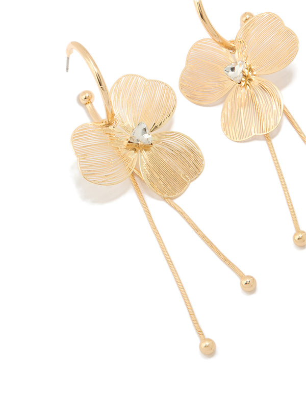 Featuring statement style laser cut flower drop earrings in gold close up view