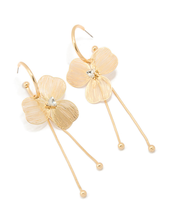 Showcasing statement style laser cut flower drop earrings in gold front view