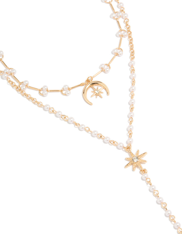 Showcasing a statement necklace featuring celestial moon and star charms with a pearl, crafted from gold plated material, close up view