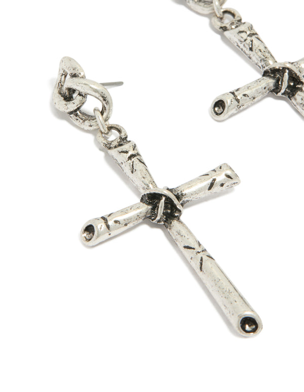 Featuring antique silver edgy textured cross drop earrings with chunky styling close up view