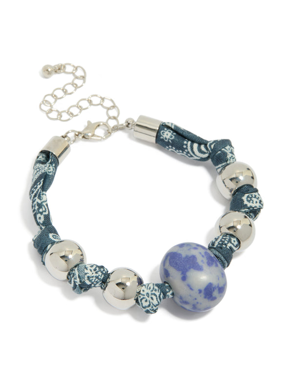 Discover this silver beaded bracelet featuring blue paisley printed fabric and a stone front view