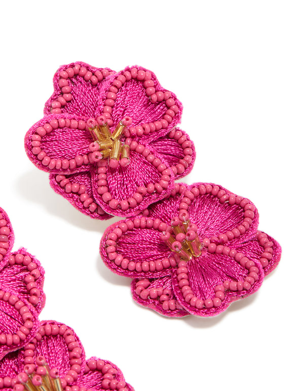 Designed with hot pink fabric beaded double flower drop earrings featuring statement design and gold accents close up view