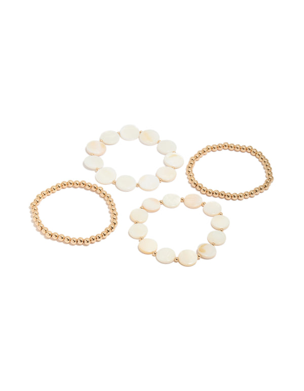 Discover this gold beaded and genuine shell discs bracelets 4-pack in ivory and beige tones featuring ocean-inspired disc design front view