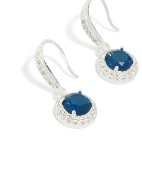 Elegant drop earrings featuring sapphire blue cubic zirconia with halo cut and plated finish close up view