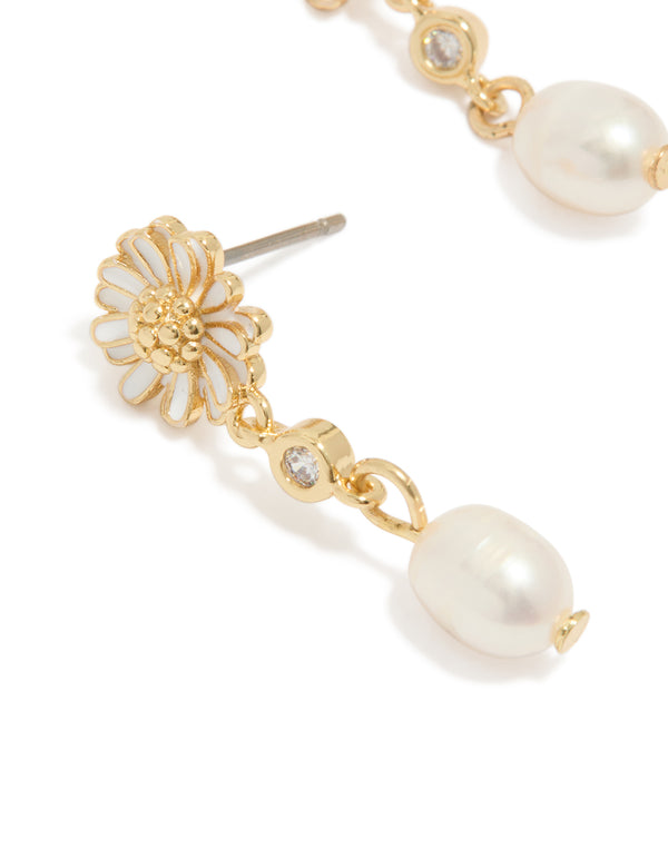 Highlighting gold plated white enamel daisy and freshwater pearl drop earrings with floral design close up view