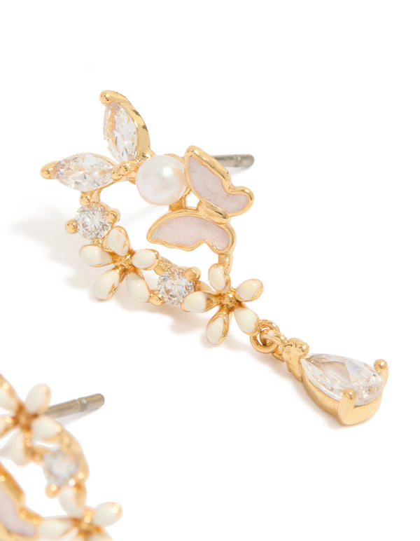 Showcasing gold plated cubic zirconia and pink enamel butterfly cluster drop earrings featuring pearl accents and pear stone cut close up view